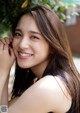 A young woman with long brown hair smiling at the camera.