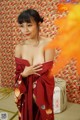 A woman in a red kimono posing for the camera.