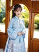 a woman in a blue dress standing in front of a door