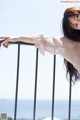 A woman leaning on a railing with her hand on the railing.