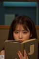 A young woman is reading a book in a library.