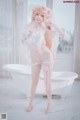 A woman in a white lingerie posing in a bathtub.