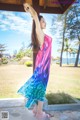 A woman in a colorful dress standing on a patio.