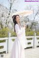 A woman in a pink dress holding an umbrella.