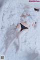 A woman laying on top of a fluffy white blanket.