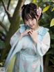 A woman in a blue and white hanbok posing for a picture.