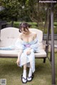 A woman in a blue dress sitting on a white chair.