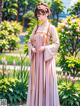 A woman in a pink dress standing in a garden.