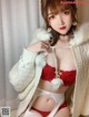 a woman in a white sweater and red lingerie posing for the camera