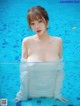 A woman in a white shirt is standing in a pool.