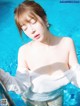 A woman in a white shirt is standing in a pool.