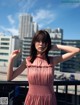 A woman in a pink dress standing on a balcony.