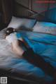 A woman laying on a bed with headphones on.