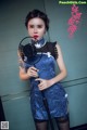 A woman in a blue dress holding a fan.